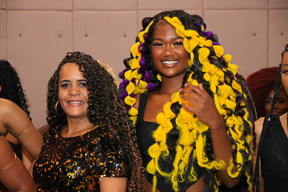 duas mulheres negras com cabelos cacheados sorrindo